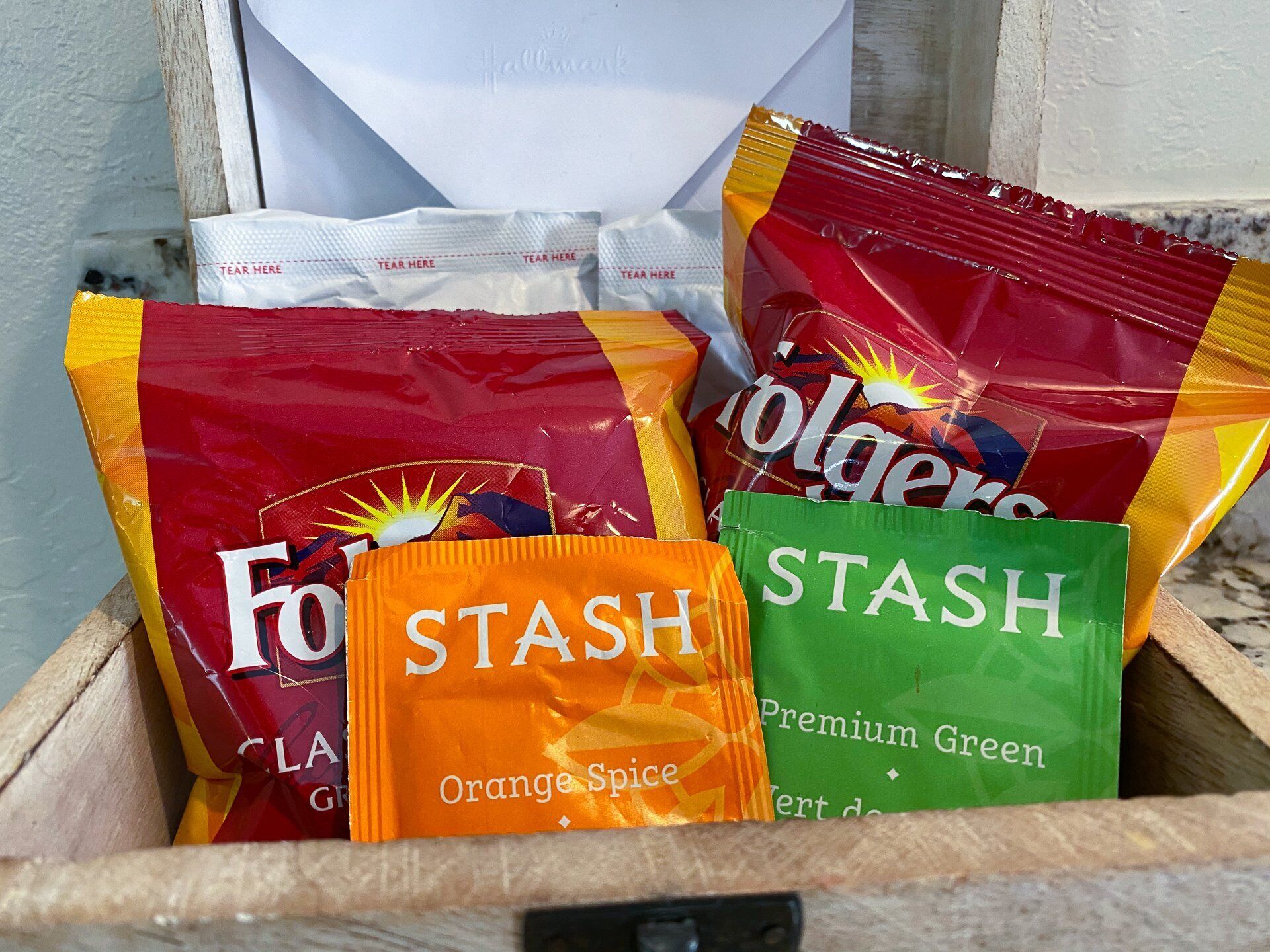 Eine Holzkiste mit verschiedenen Snacks, darunter Frooti, Frooti Orange Spice und Frooti Premium Green.