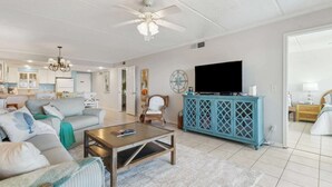 A spacious living room with a sofa, coffee table, and a television. - J1 Amelia South (Fernandina Beach)