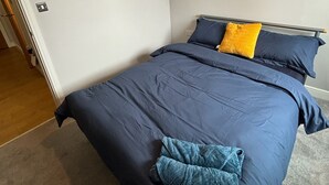 Una camera da letto con un letto, un comodino e una porta.