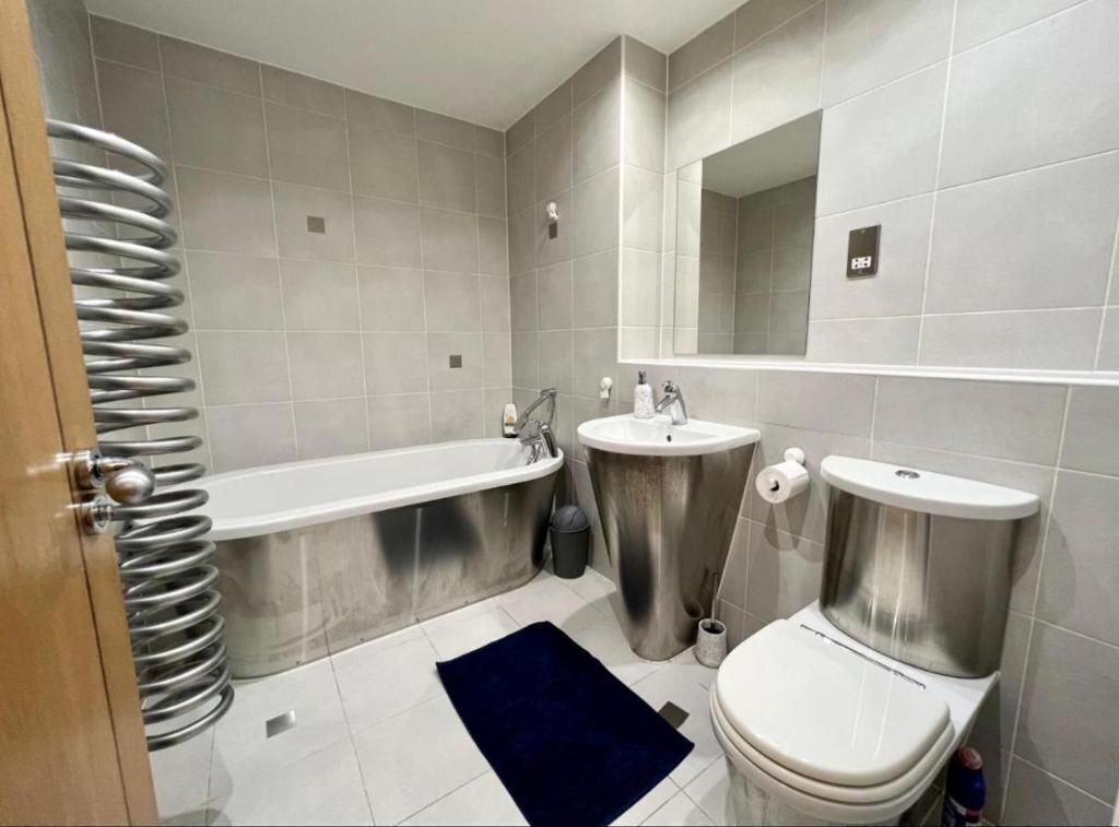 A modern bathroom with a bathtub, sink, and toilet.