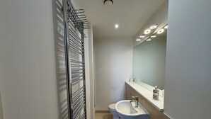 A modern bathroom with a toilet, sink, and a towel rack. - 4 Bed 2 Bath Balcony Retreat - 15min-O2 Arena! (London)