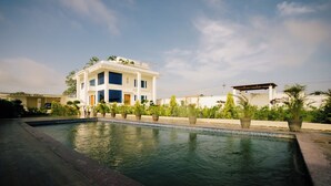 Un edificio moderno de dos pisos con una piscina al frente.