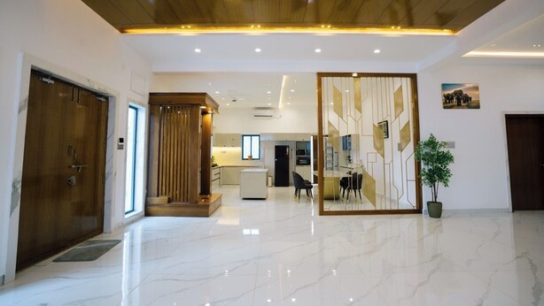 Un vestíbulo espacioso con suelo de mármol, techo de madera y una partición decorativa.