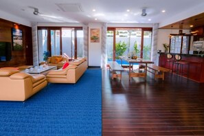 Un hall de hotel con una zona de estar, piscina y bar.