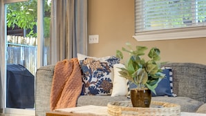 A living room with a grey sofa, a brown throw blanket, and a potted plant on a wooden table. - 3754 Red Canon (Colorado Springs)