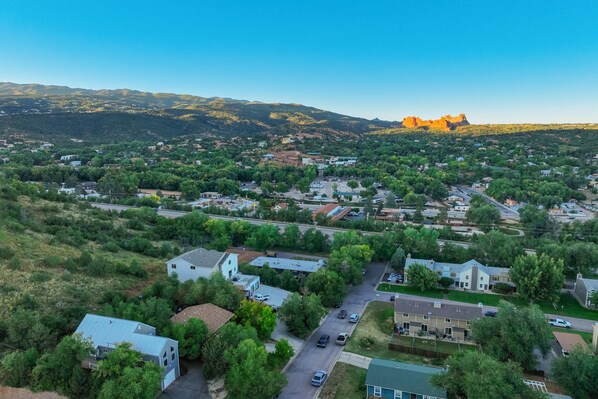 Une vue aérienne d’un quartier résidentiel, avec des maisons, des routes et une montagne en arrière-plan.