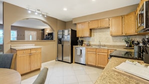 A modern kitchen with wooden cabinets, stainless steel appliances, and a granite countertop. - 3754 Red Canon (Colorado Springs)