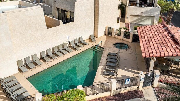 Une piscine sur le toit, dotée de chaises longues, d’un jacuzzi et d’un espace patio avec des sièges extérieurs.
