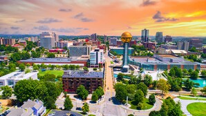 A cityscape with modern buildings, a prominent spherical structure, and a mix of green spaces and urban development. - Pineview Haven (Knoxville)