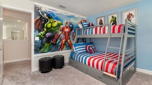 A child's bedroom with a bunk bed, superhero-themed wall art, and a blue wall. - KCC 4797 (Kissimmee)