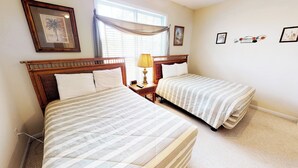 A hotel room with two beds, a nightstand with a lamp, a clock, and framed artwork on the walls. - Village at the Glens G 109 (Little River)