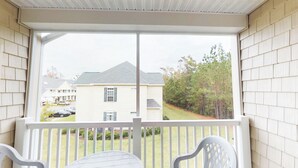 A porch with white railings and a view of a house with a grey roof and white siding. - Village at the Glens S 205 (Little River)