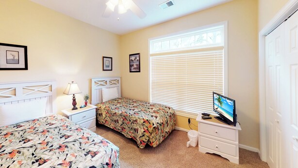 A bedroom with two beds, a TV, and a window with blinds. - Village at the Glens S 205 (Little River)