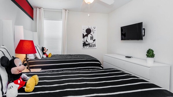 A hotel room with two beds, a TV, a lamp, and a Mickey Mouse plush toy. - Kcc4741 (Kissimmee)