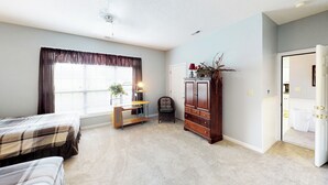 A bedroom with a bed, a desk, a chair, a wardrobe, and a window with curtains. - Village at the Glens C 204 (Little River)