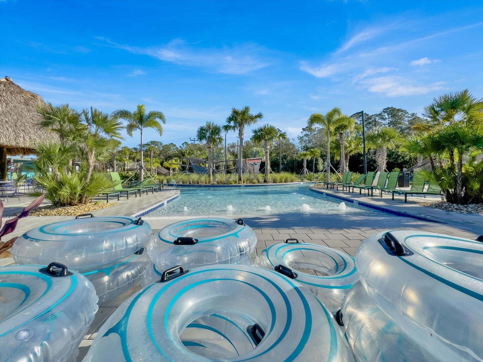 A pool area with multiple water slides, lounge chairs, and palm trees.