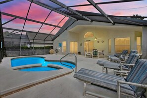 Une piscine extérieure couverte, dotée de chaises longues et d’un espace patio.