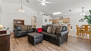 Un soggiorno con divano, tavolino, camino e zona pranzo con tavolo e sedie.