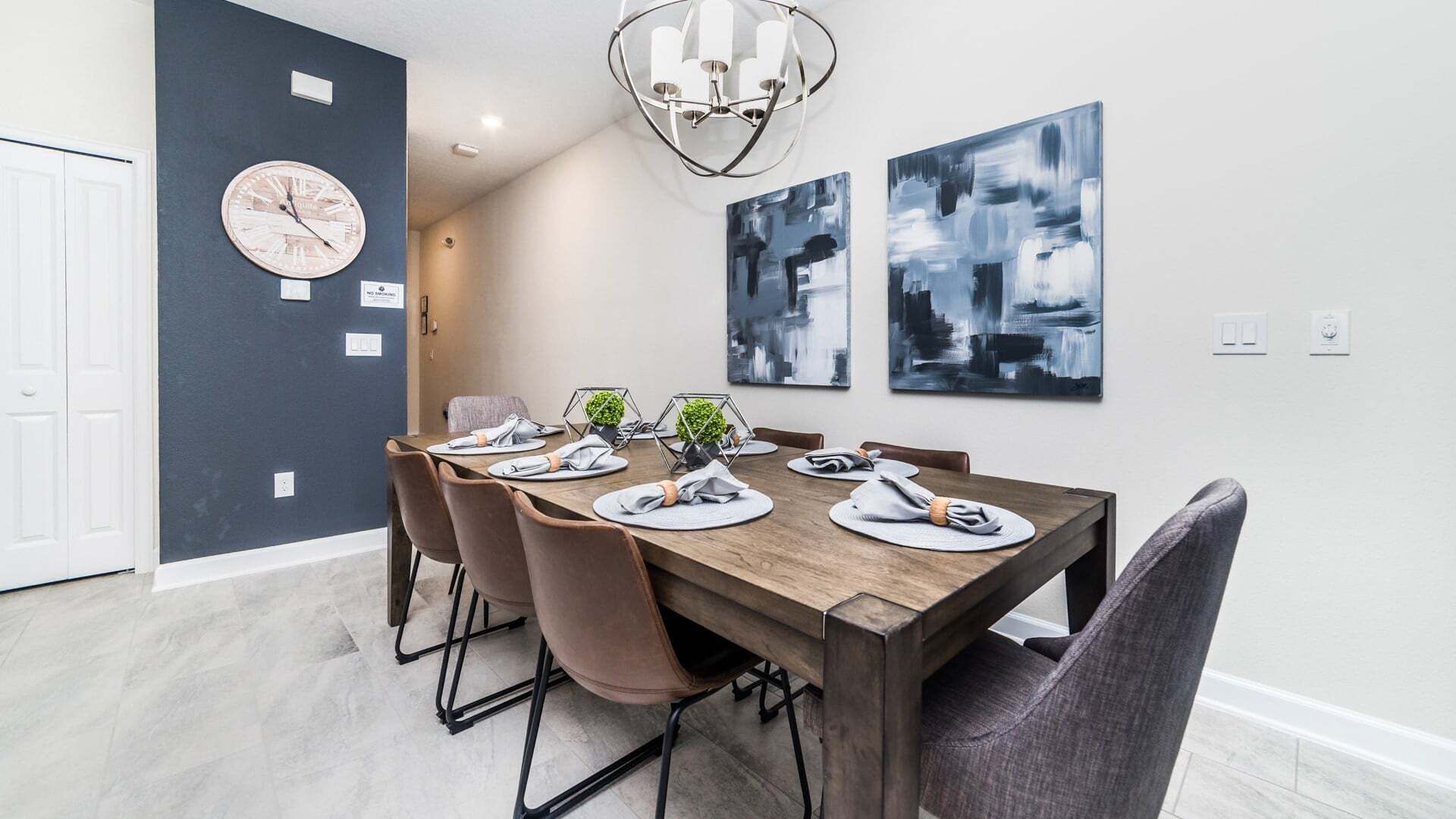 Un espace repas comprenant une table en bois, des chaises et un lustre.