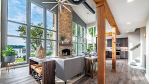 Una cocina moderna con ventanas amplias, una chimenea de piedra y un techo de madera.