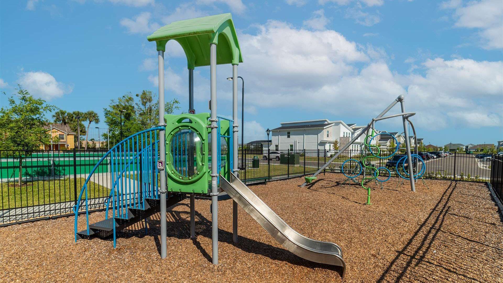 A playground with a slide, climbing structures, and a covered area.