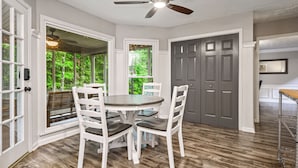 A dining area with a round table, white chairs, and a ceiling fan. - 1356 Velvet Creek Glen, Marietta (Marietta)