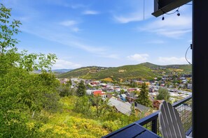 Un balcon avec vue sur la ville et les collines.