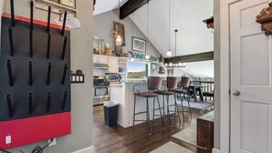 A kitchen with a central island, bar stools, and a view of the outdoors. - Treasure Hill House Ski-in Ski-out PCMR, sleeps 21 (Park City)