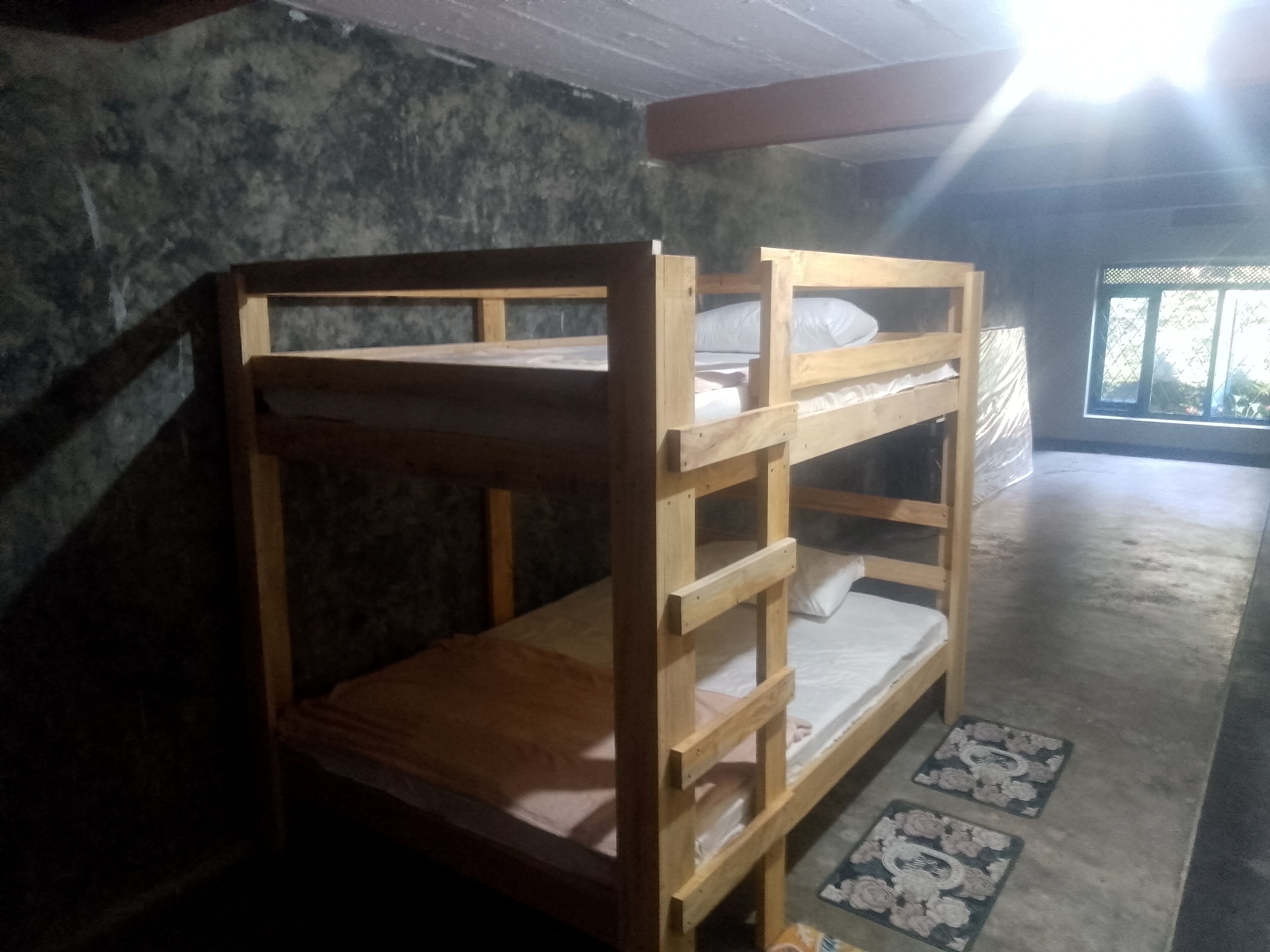A bunk bed with a wooden frame and a mattress.