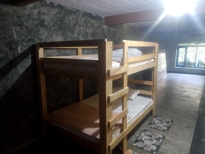 Una cama litera con estructura de madera y un colchón.