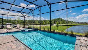A covered outdoor swimming pool with a view of a lake and trees. - 4300pw · Brand New Storey Lake 8BR Villa With Lake View (Kissimmee)