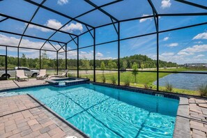 A covered outdoor swimming pool with a view of a lake and trees. - 4300pw · Brand New Storey Lake 8BR Villa With Lake View (Kissimmee)