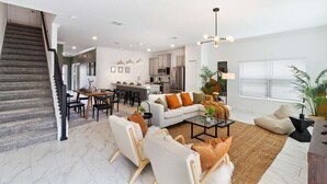 A spacious living area with a staircase, a dining area, and a kitchen. - 4184pd · 20% OFF Weekly Stay/ 5br/free Water Park (Kissimmee)