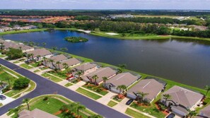 A residential area with houses, a lake, and a road. - 1061 Lake Berkley 4 Bed With Pool (Kissimmee)