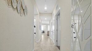 A hallway with a tiled floor, white walls, and doors with mirrored panels. - 3161 Paradox Circle, Unit 406 Kissimmee, 2 Beds (Kissimmee)