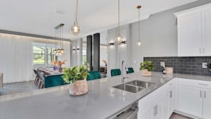 A modern kitchen with a large island, stainless steel appliances, and pendant lighting. - 3017ps · Brand New Luxury 9BR Villa/ Pool/spa/game Room (Kissimmee)