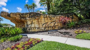 A rock wall with the inscription "Terra Verde" and a bench in a landscaped garden area. - 201-4-hb-beautiful Home at Terraverde (Kissimmee)