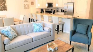 A modern living room with a sofa, armchair, and coffee table. - Special Offer Townhome at Compass Bay (Kissimmee)