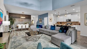 Ein modernes Wohnzimmer mit einer Eckcouch, einem Couchtisch und einem Essbereich mit Tisch und Stühlen.