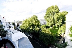 A high-rise building with a rooftop terrace, surrounded by greenery and other buildings. - Notting Hill luxury 1 bedroom apartment + balcony. (London)