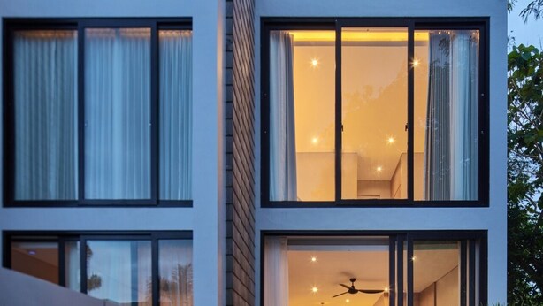Un immeuble moderne à plusieurs étages, doté de grandes fenêtres et de balcons.