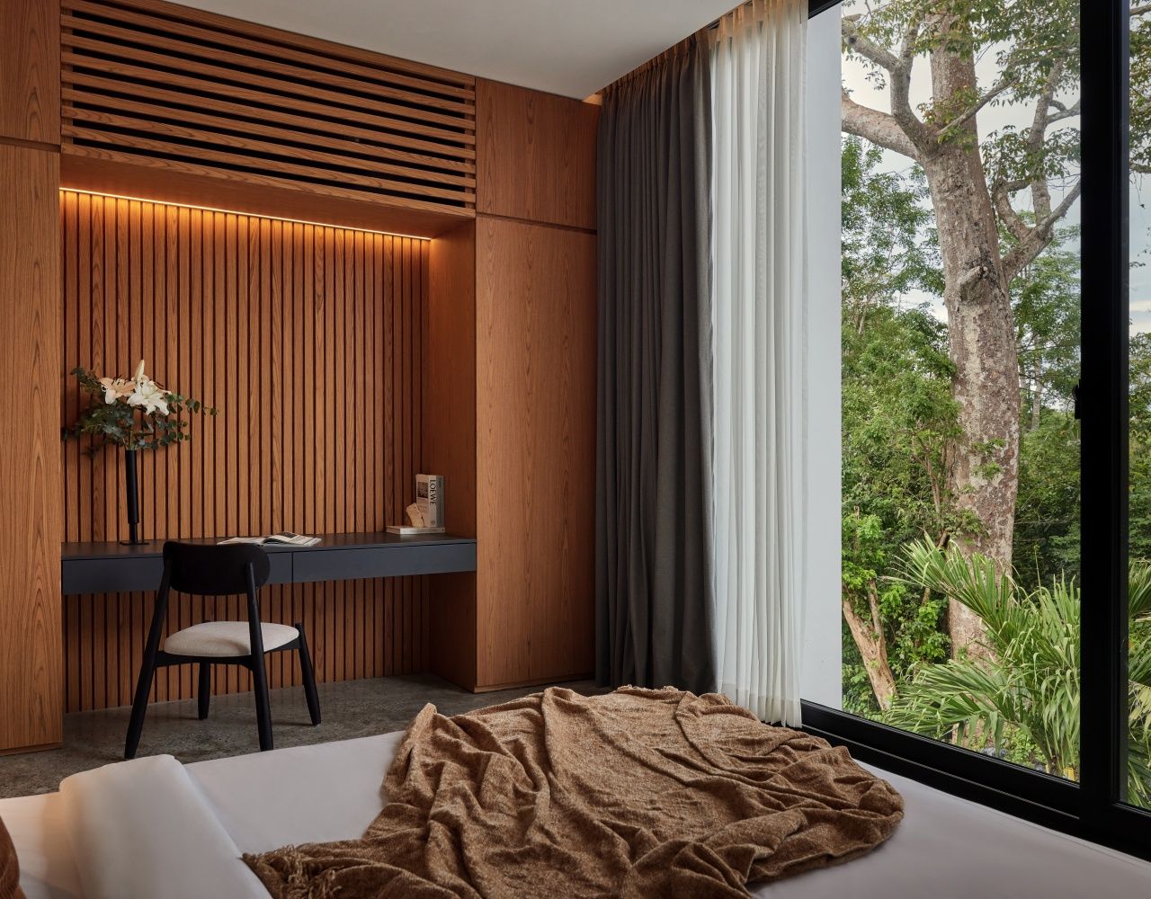 Un dormitorio con cama, escritorio y vistas a zonas verdes.