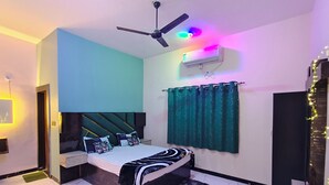 Una camera da letto con un letto, una ventola a soffitto, un condizionatore d'aria e una finestra con tende.