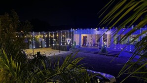 Un edificio con ingresso ben illuminato e un'area esterna coperta.