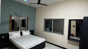 Una camera da letto con un letto, una ventola a soffitto, una finestra e uno specchio.