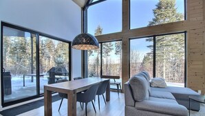 Een modern interieur met grote ramen, een eethoek en een gezellige zithoek.