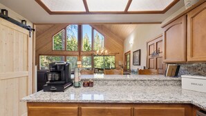 A kitchen with a large island, wooden cabinets, and a coffee maker.