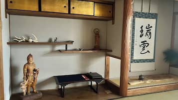 A traditional Japanese room with tatami flooring, a shoji screen, and a calligraphy scroll.
