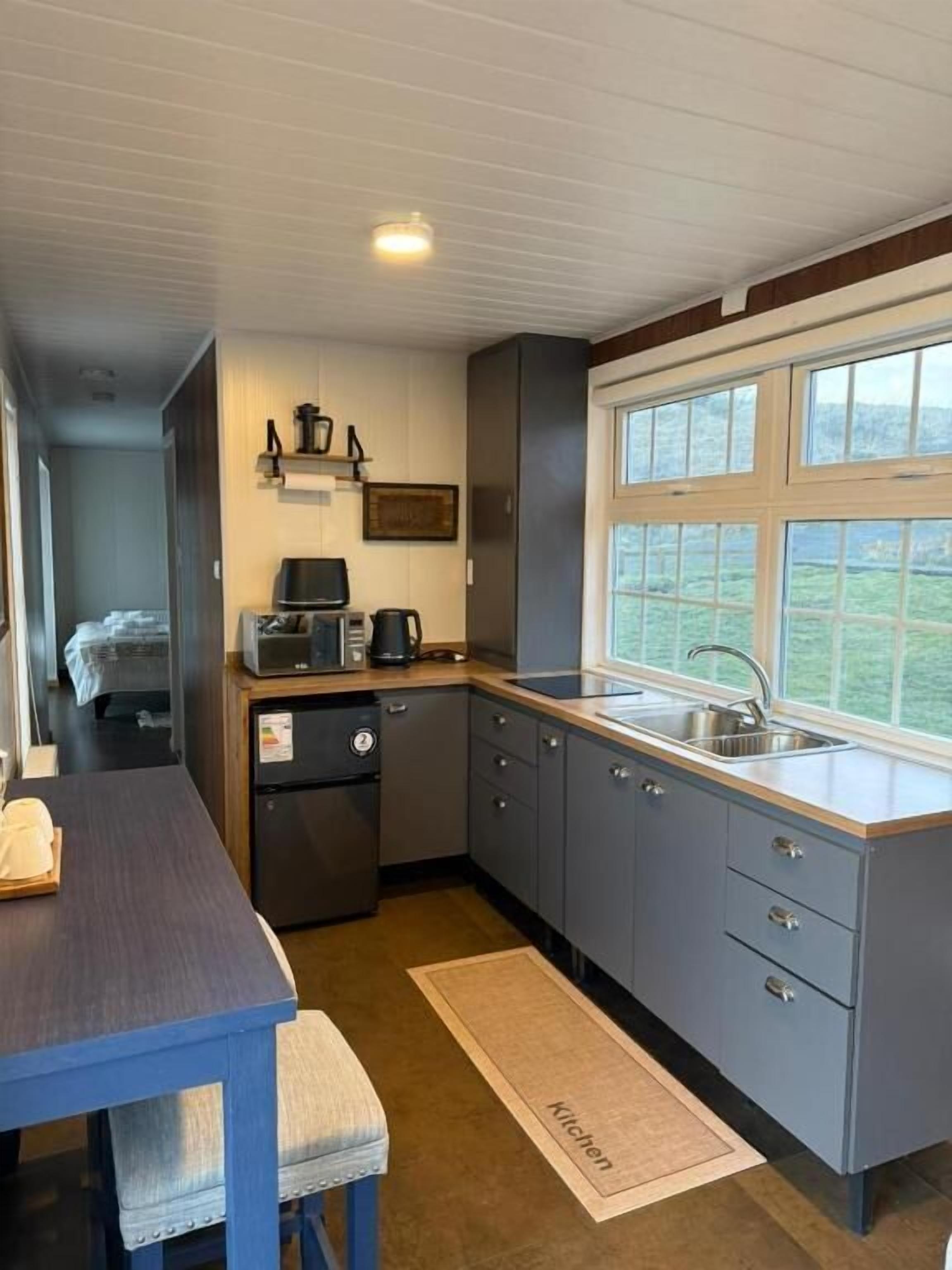 Frigobar, micro-ondas, cooktop, talheres/pratos/utensílios de cozinha