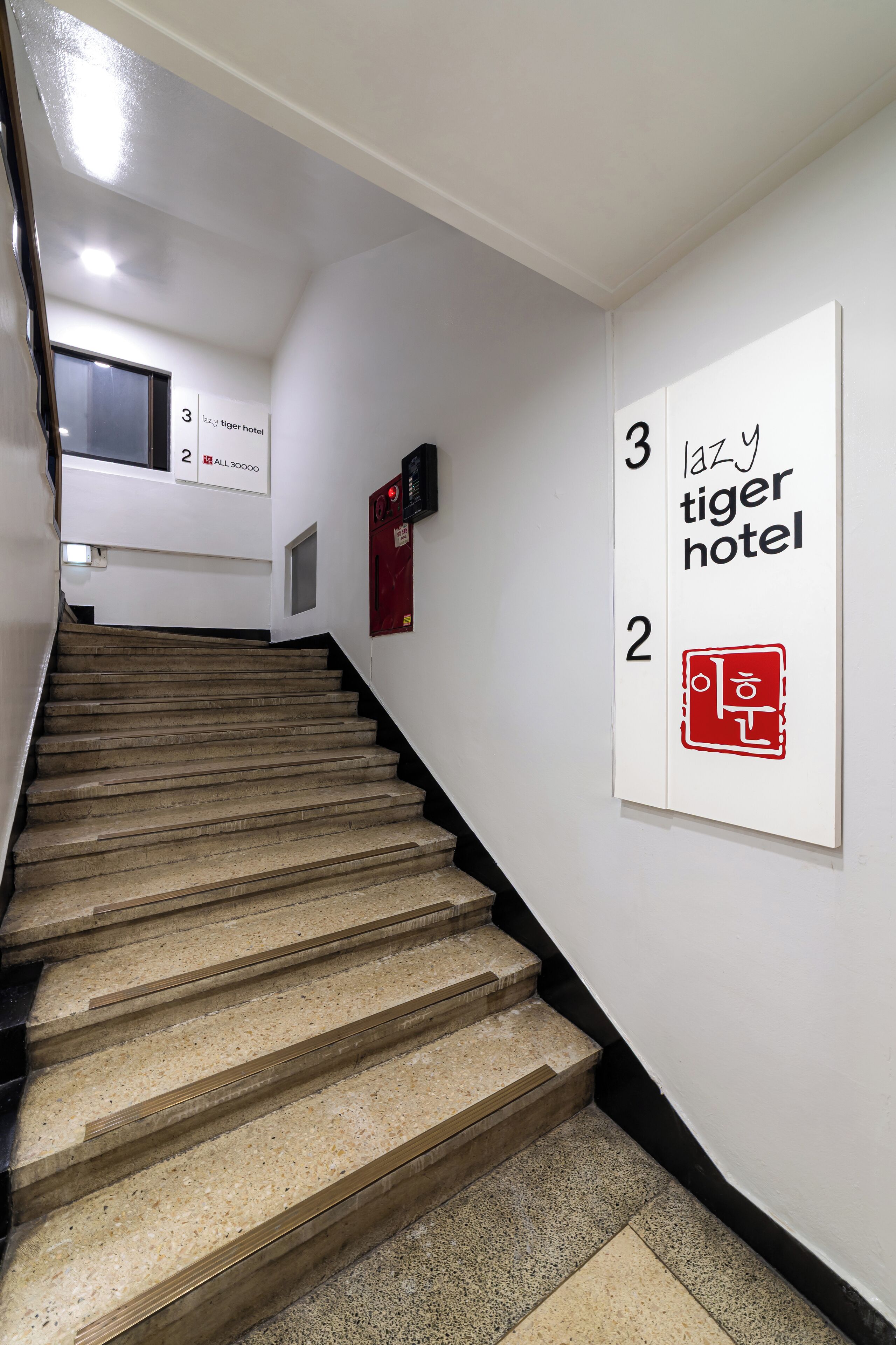 A staircase in a hotel with numbered signs indicating room levels.